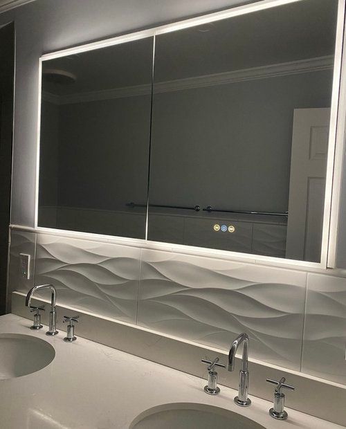 A bathroom with two sinks and a large mirror.