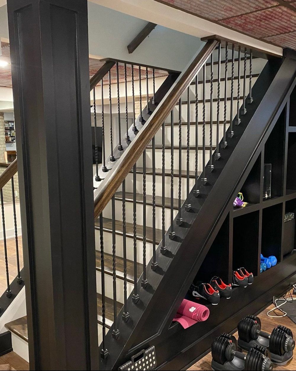 A staircase with a railing and a shelf underneath it