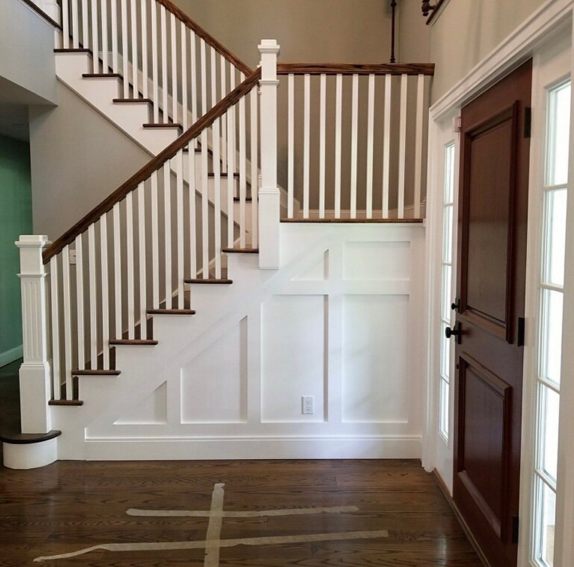 A hallway with a staircase and a door
