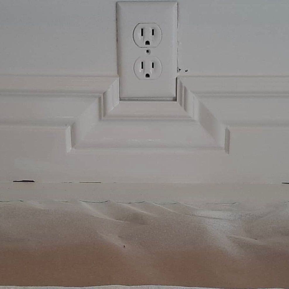 A white electrical outlet on a white wall