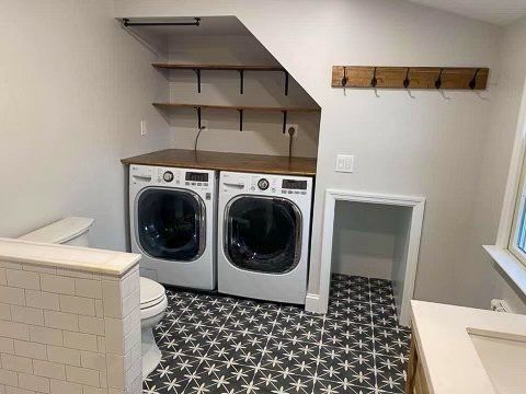 A laundry room with a washer and dryer , toilet , and sink.