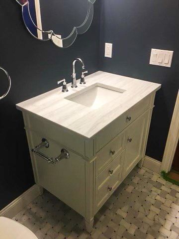 A bathroom with a sink , mirror and toilet.