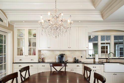 A kitchen with a table and chairs and a chandelier hanging from the ceiling.