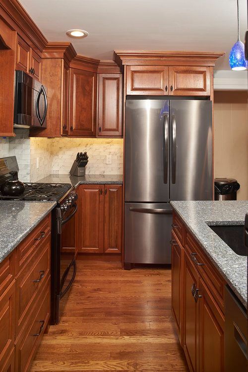 A kitchen with stainless steel appliances and wooden cabinets.