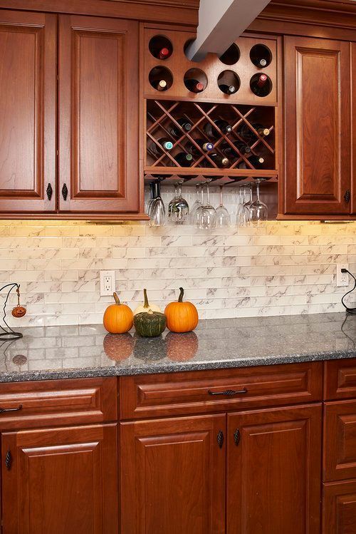A kitchen with wooden cabinets and a wine rack
