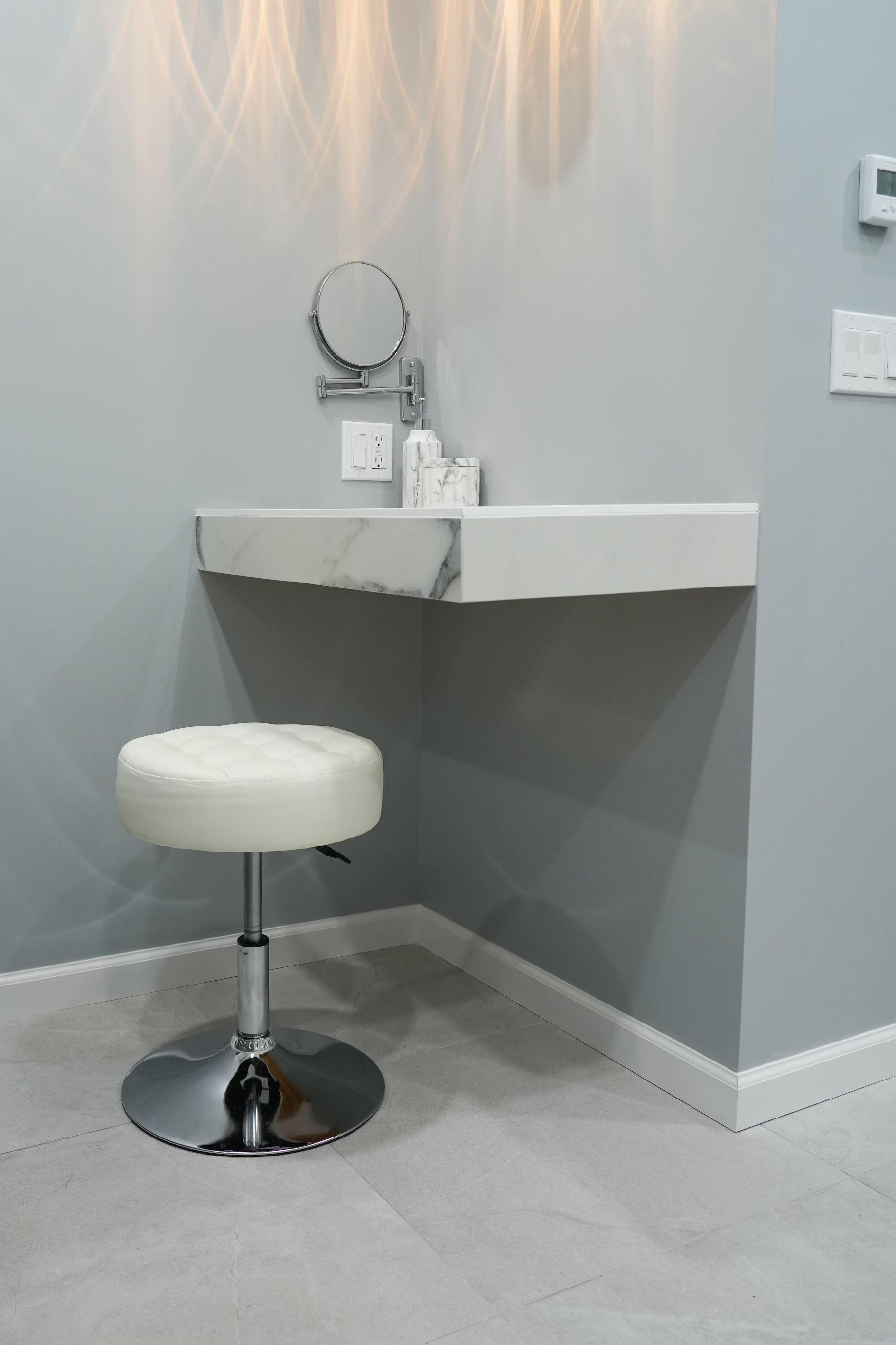 A bathroom with a sink, mirror, and stool.