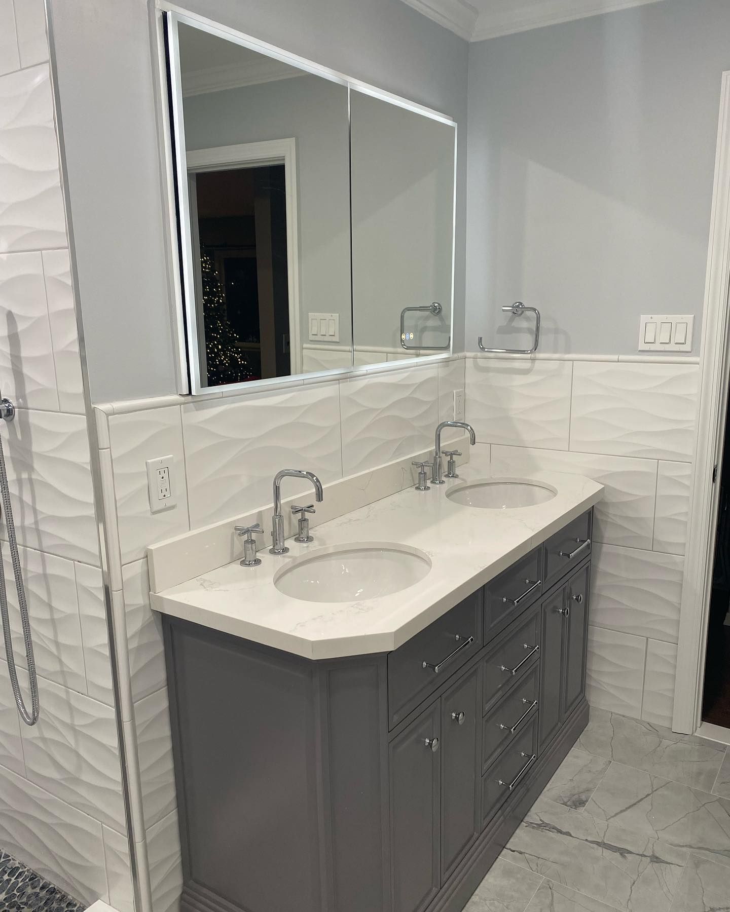 A bathroom with two sinks and a large mirror.