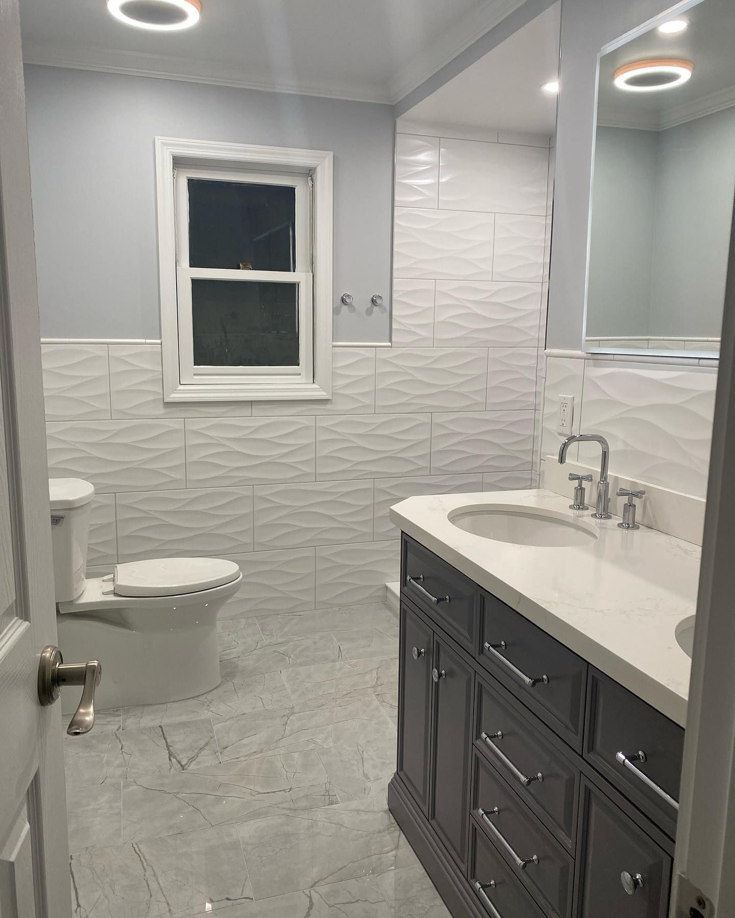 A bathroom with a toilet , sink and mirror