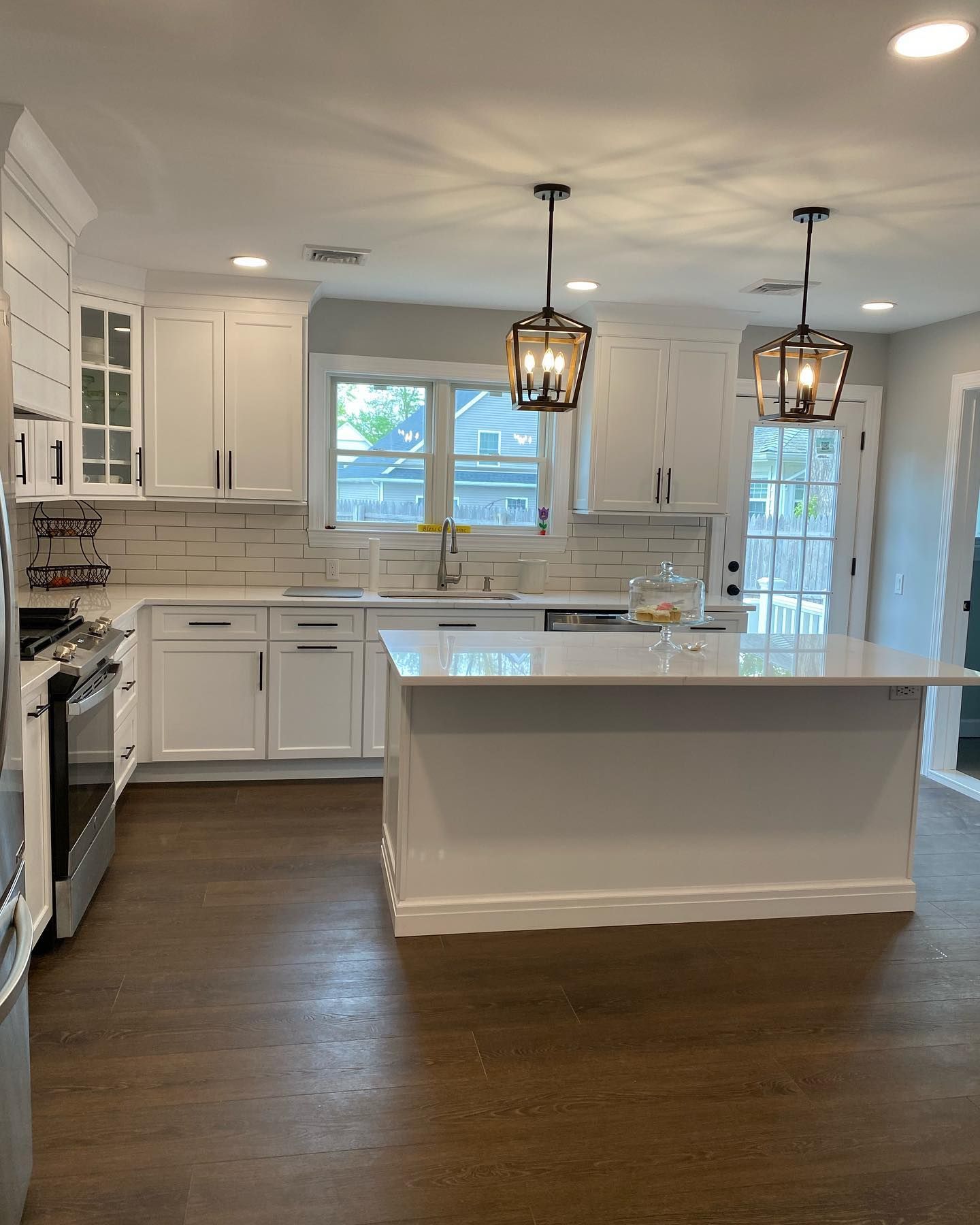A kitchen with white cabinets and a large island in the middle