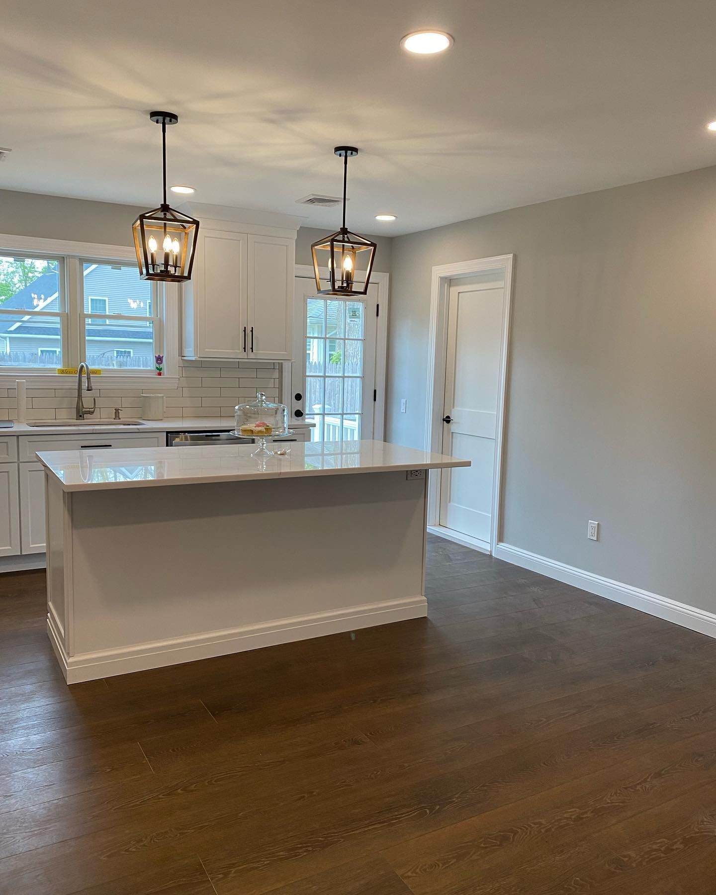 An empty kitchen with white cabinets and a large island