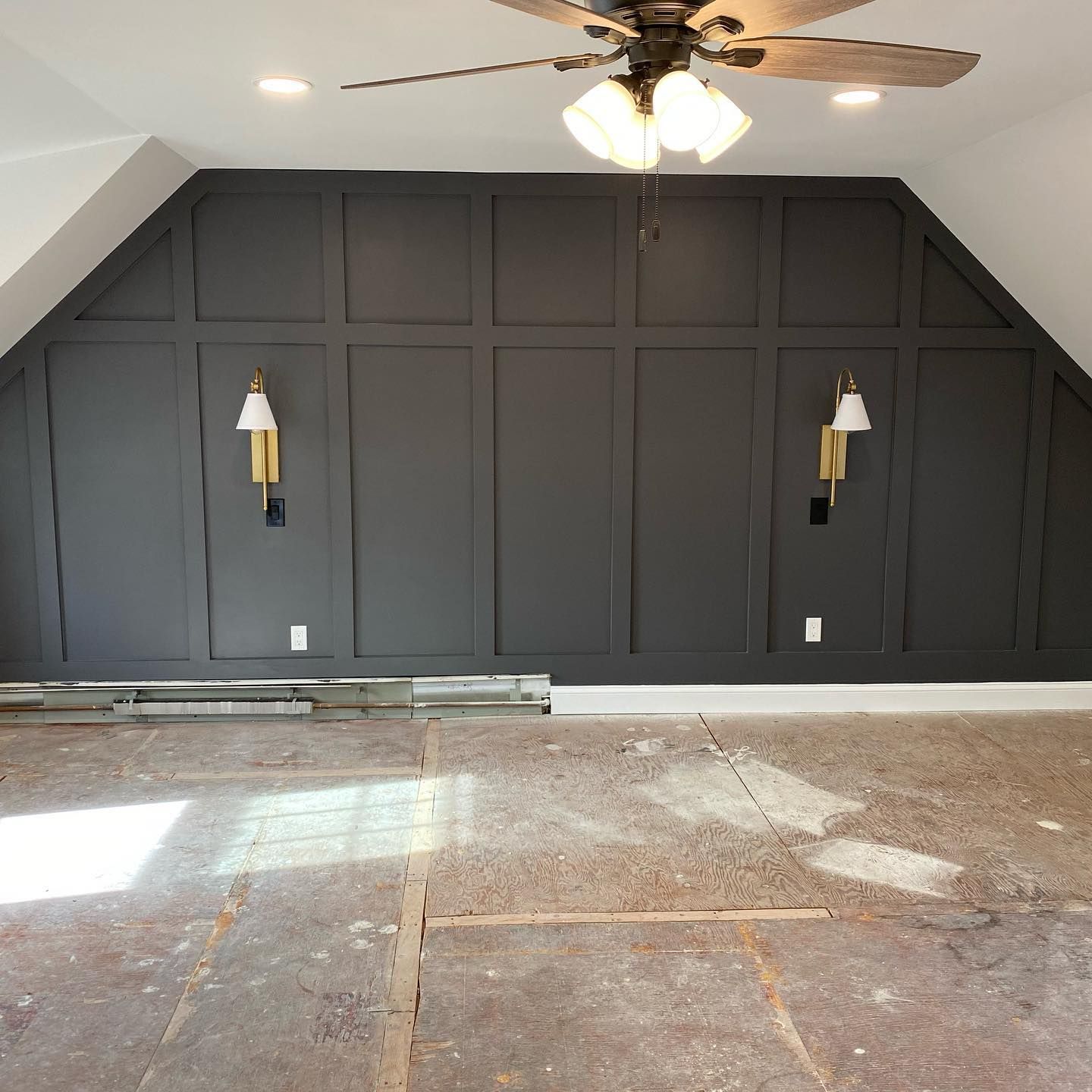 A room with black walls and a ceiling fan