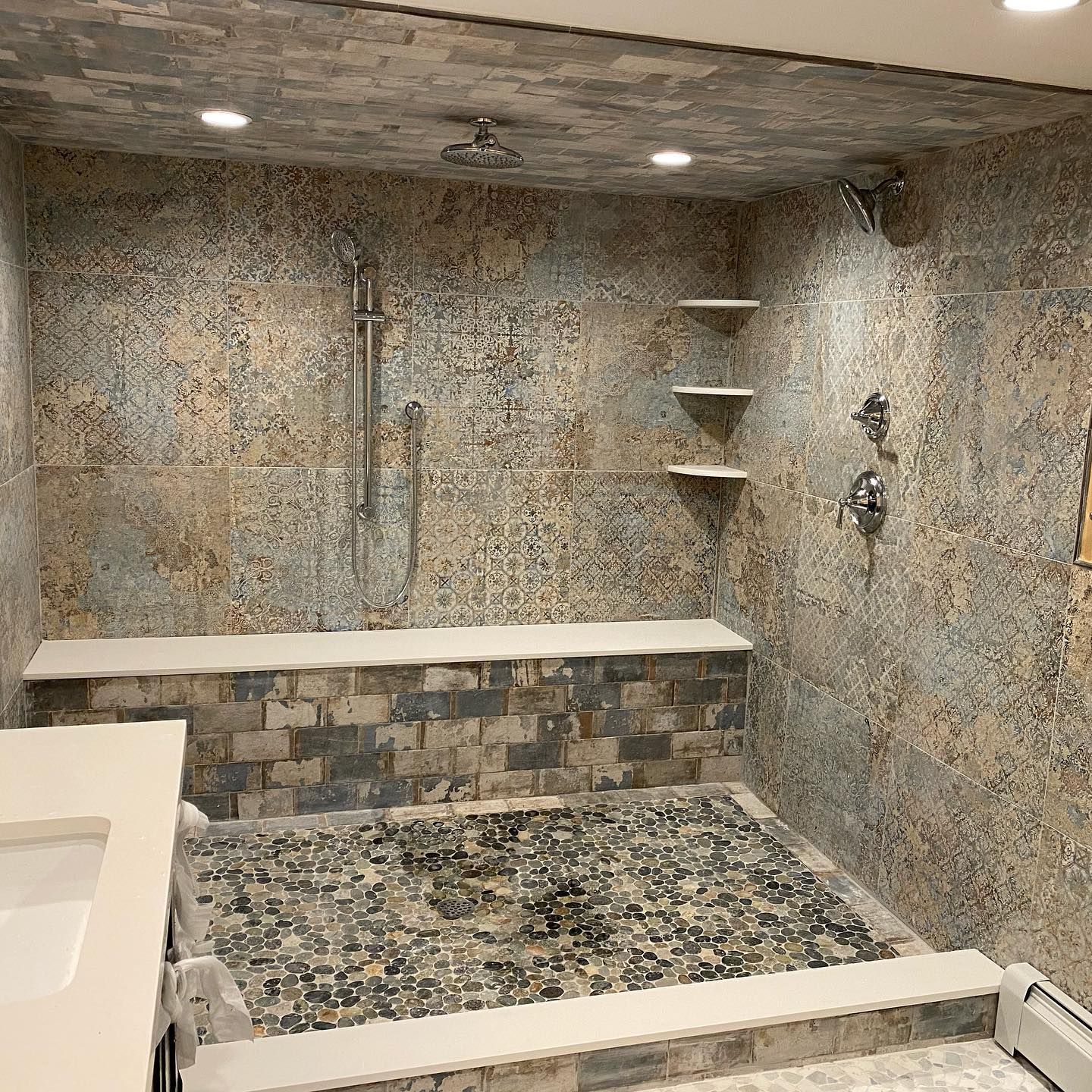 A bathroom with a walk in shower and a sink.