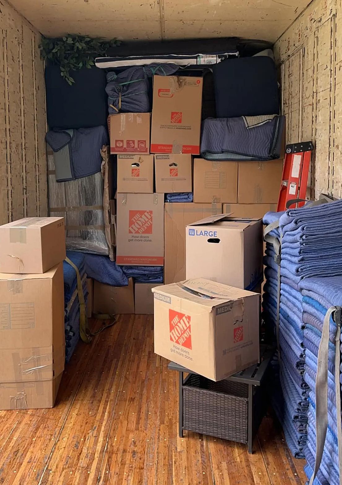Boxes and furniture packed inside a moving truck, ready for transport.