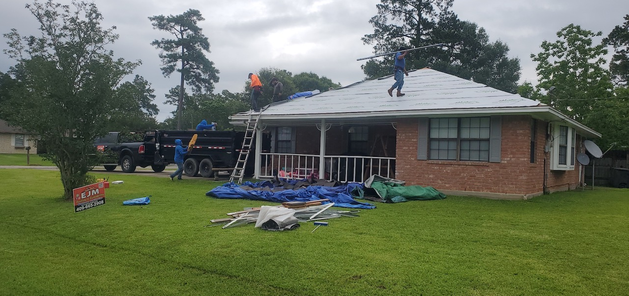 A group of people are working on the roof of a house.
