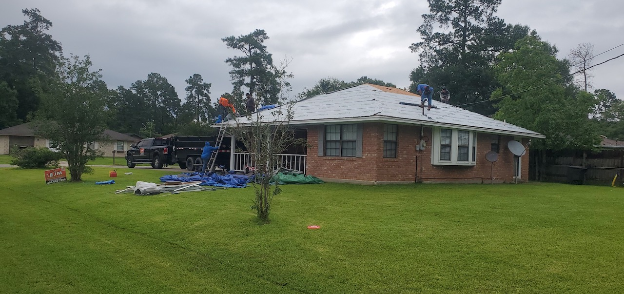 A group of people are working on the roof of a house.