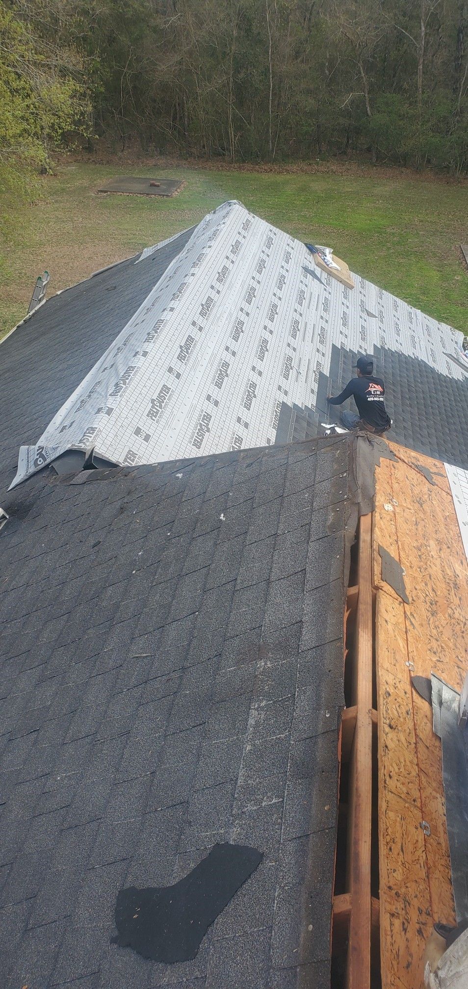A person is standing on top of a roof.