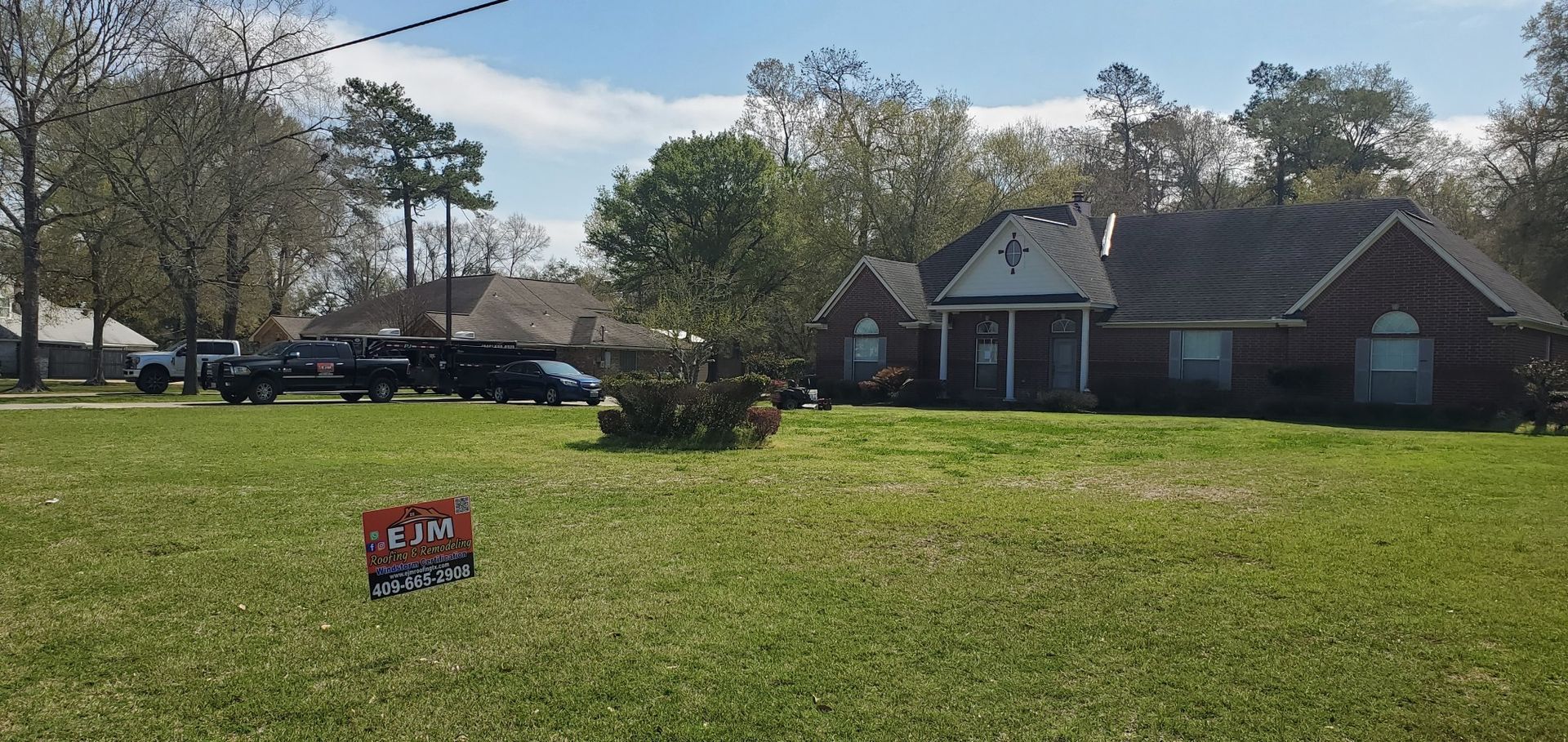 A house with a lot of grass and a sign in front of it.