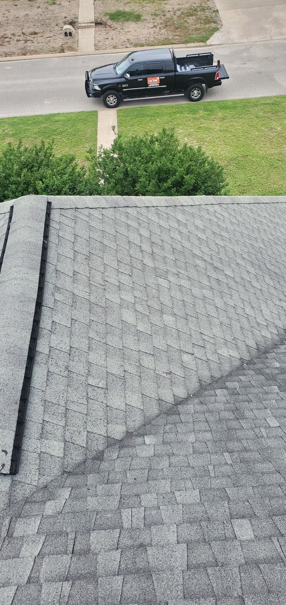A black truck is parked on top of a roof.