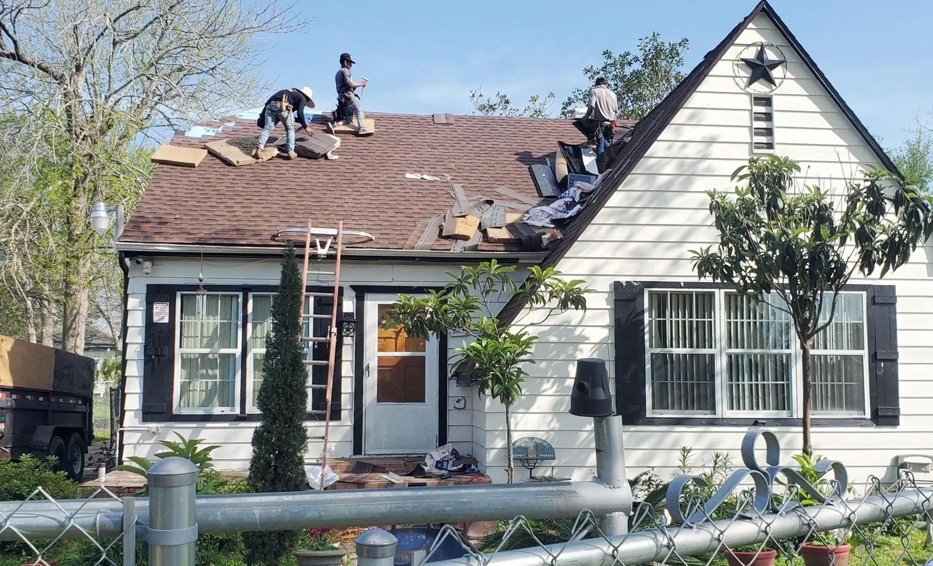 A group of people are working on the roof of a house.