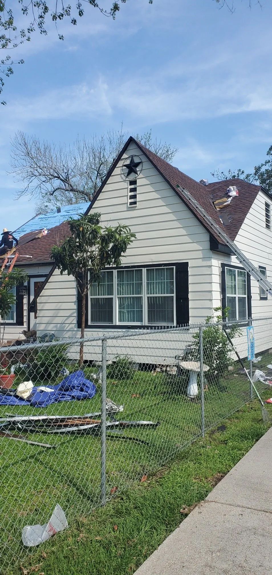 A white house with a star on the roof and a fence in front of it.