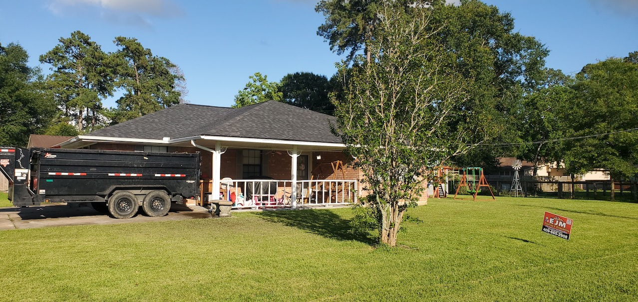 A black dump truck is parked in front of a house.