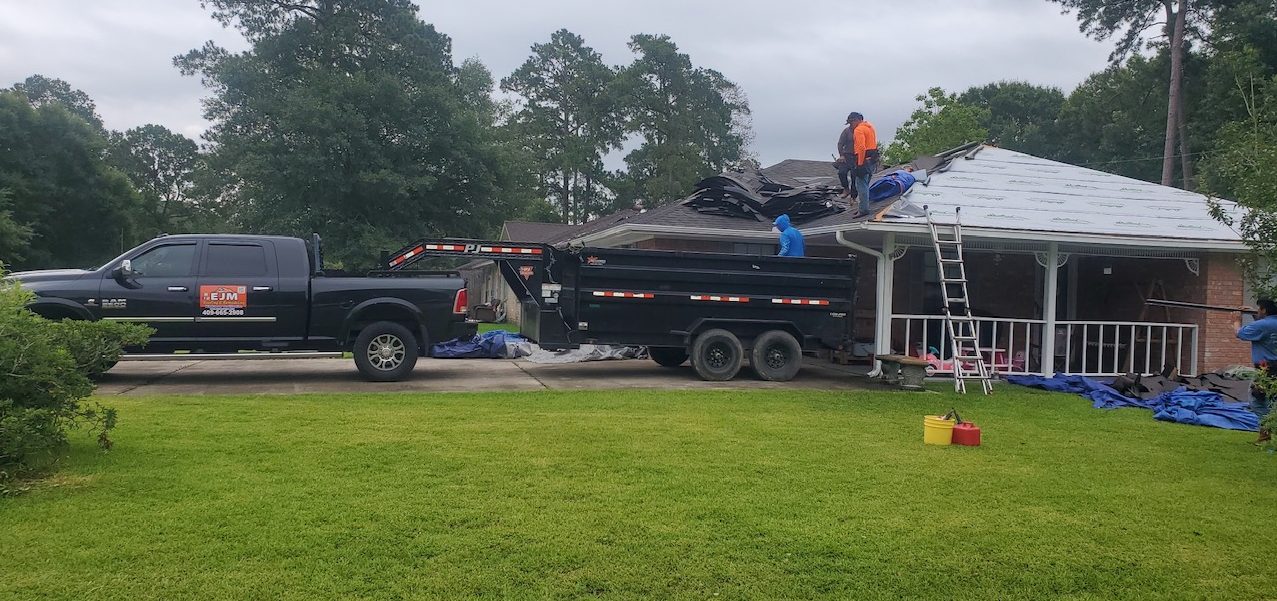 A truck and trailer are parked in front of a house.