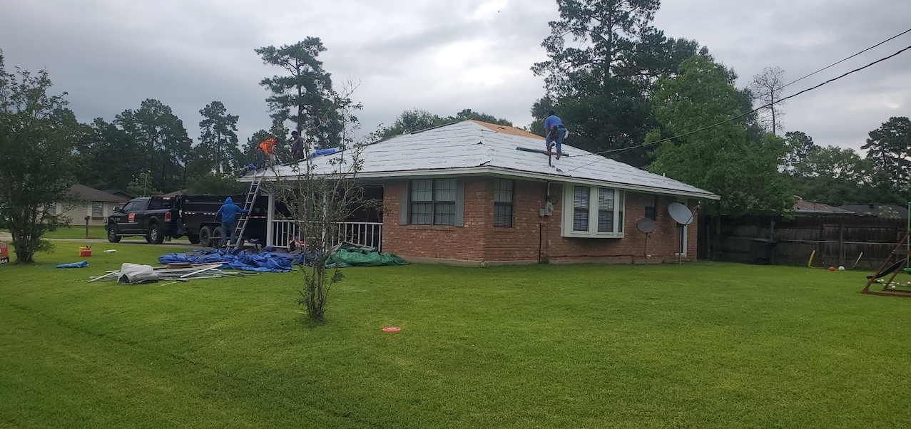 A roofer is working on the roof of a house.