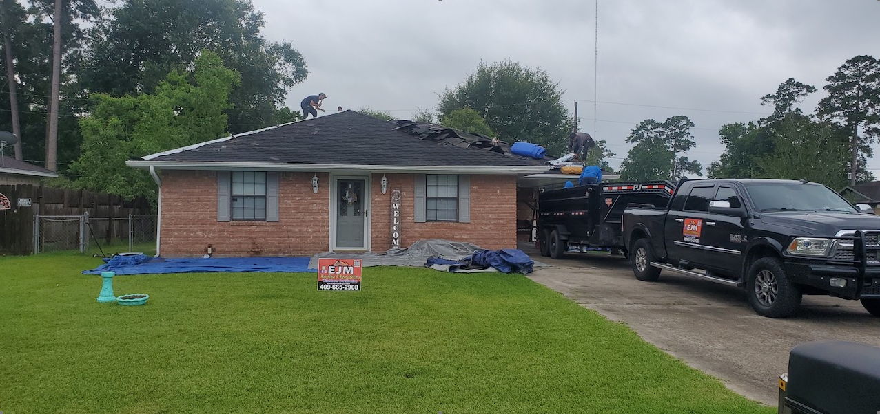A black truck is parked in front of a brick house.