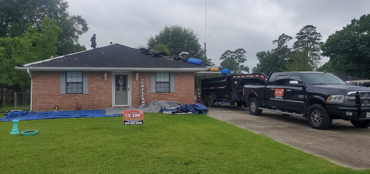 Two trucks are parked in front of a brick house.