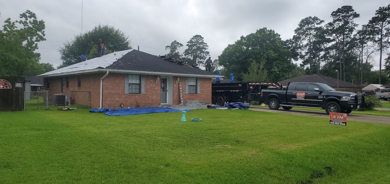 A brick house with a black truck parked in front of it.