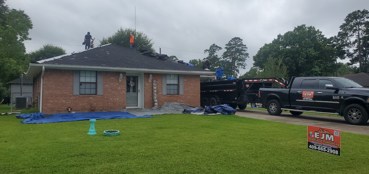 A black truck is parked in front of a brick house.