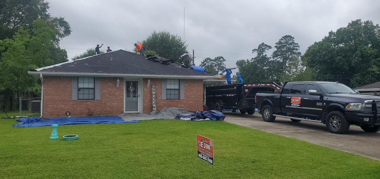 Two trucks are parked in front of a brick house.