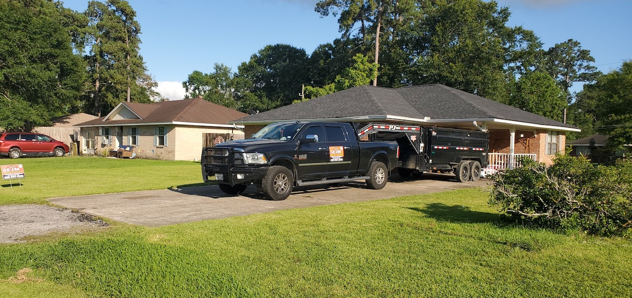 Two trucks are parked in front of a house.