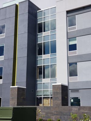 Gray and white modern building with a tall glass window section.
