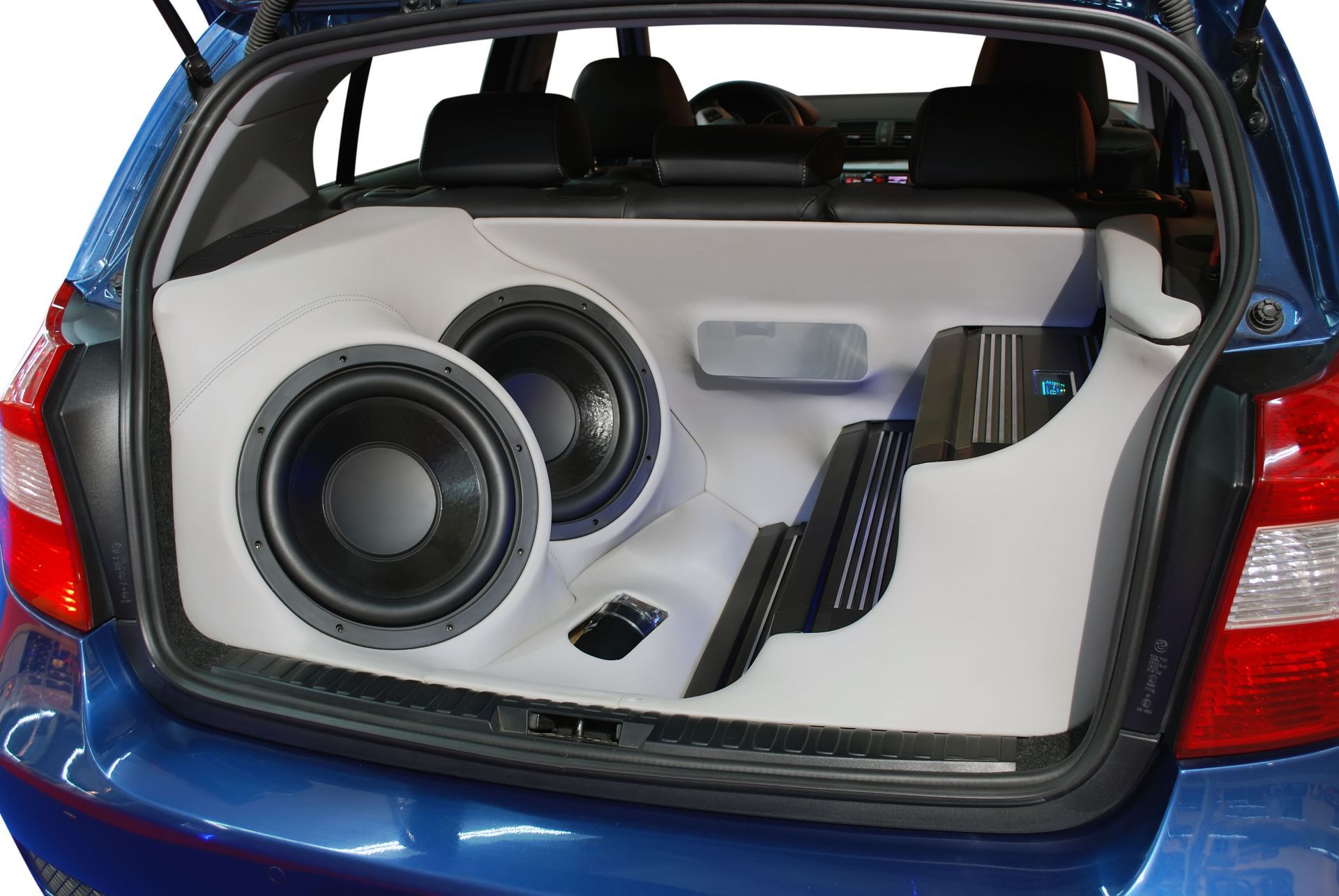 A blue car with a subwoofer in the trunk