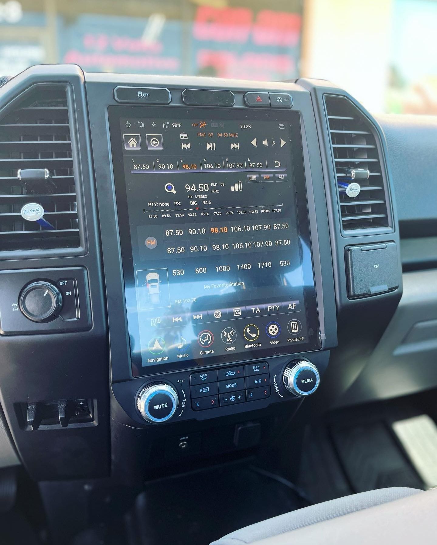 A close up of the dashboard of a car with a large screen.