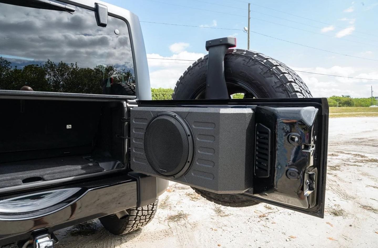 A jeep with a speaker attached to the back of it.