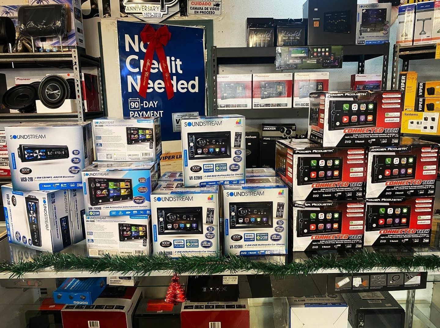A shelf full of radios and a sign that says no credit needed