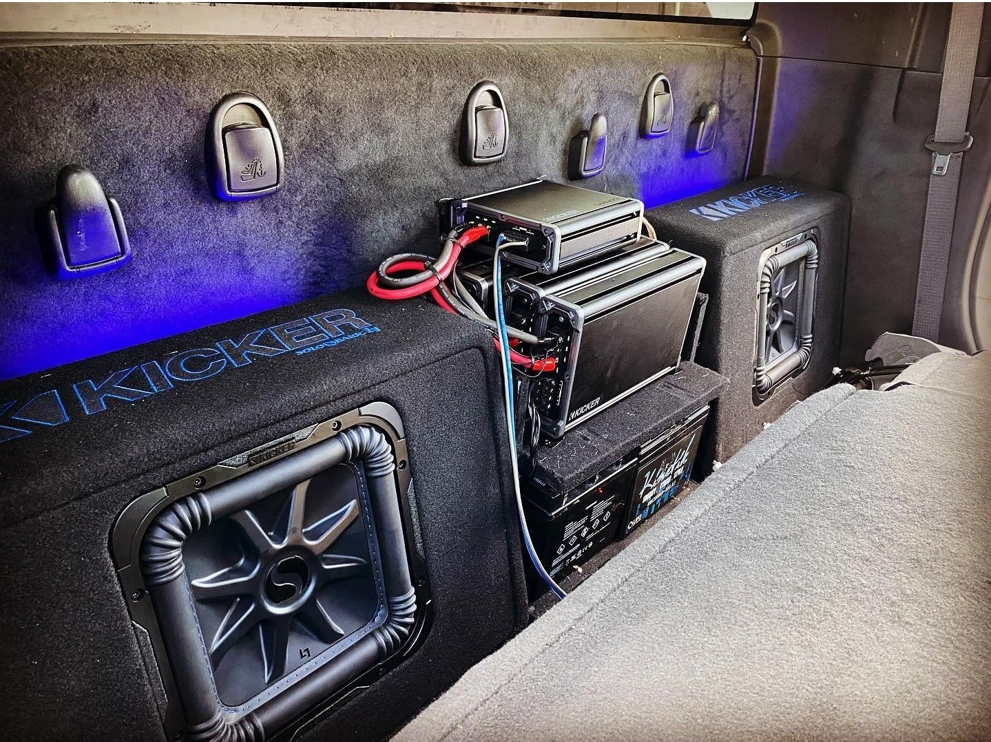 The back of a truck with a lot of speakers and amplifier.