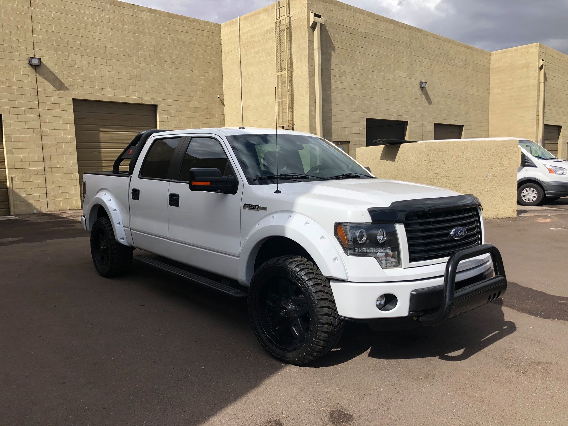 A white pickup truck is parked in front of a building.