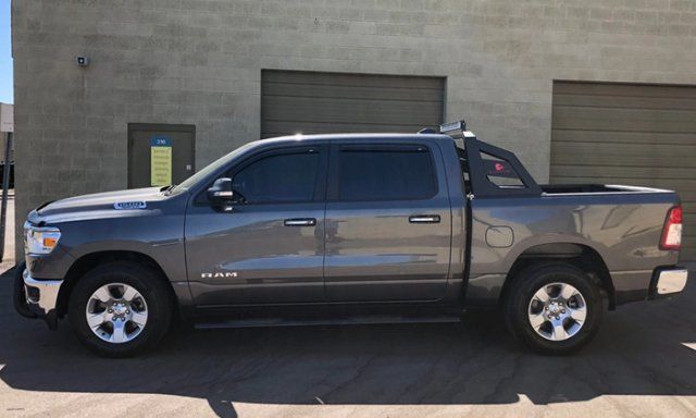 A gray truck is parked in front of a building.