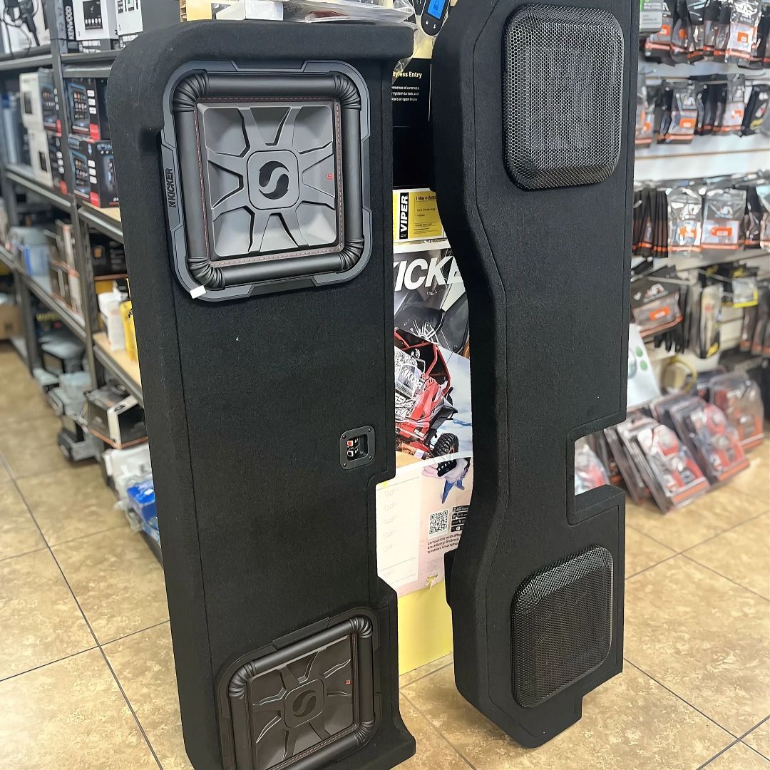 A pair of speakers are sitting on a tiled floor in a store.
