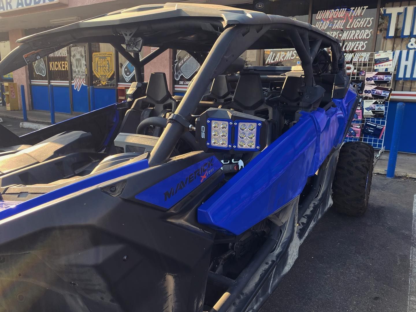 A blue and black atv is parked in front of a store