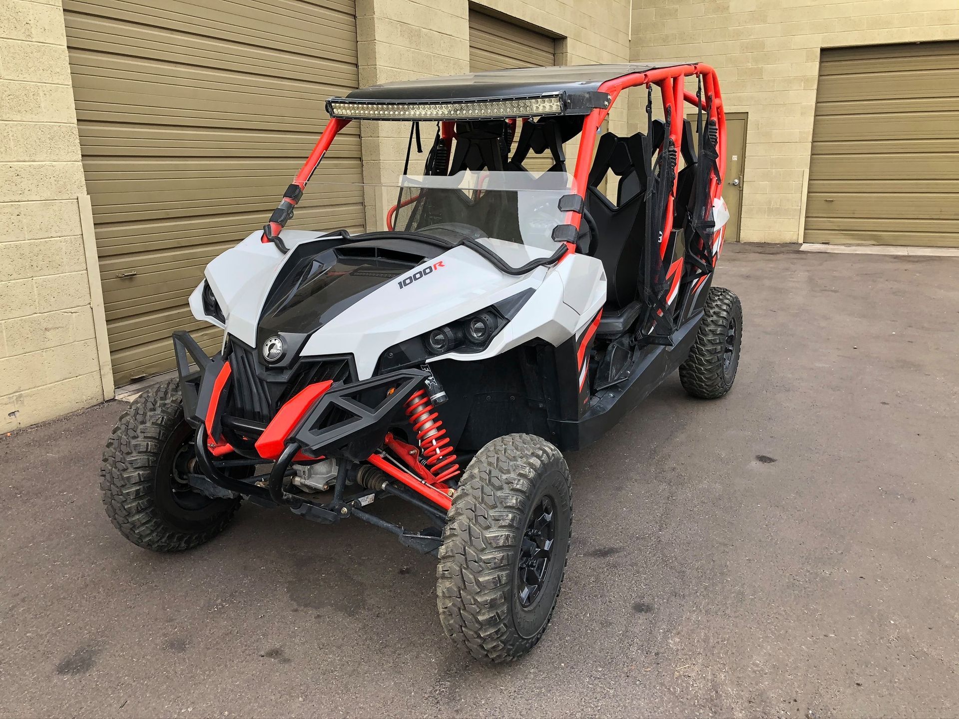 A white and red atv is parked in front of a garage.
