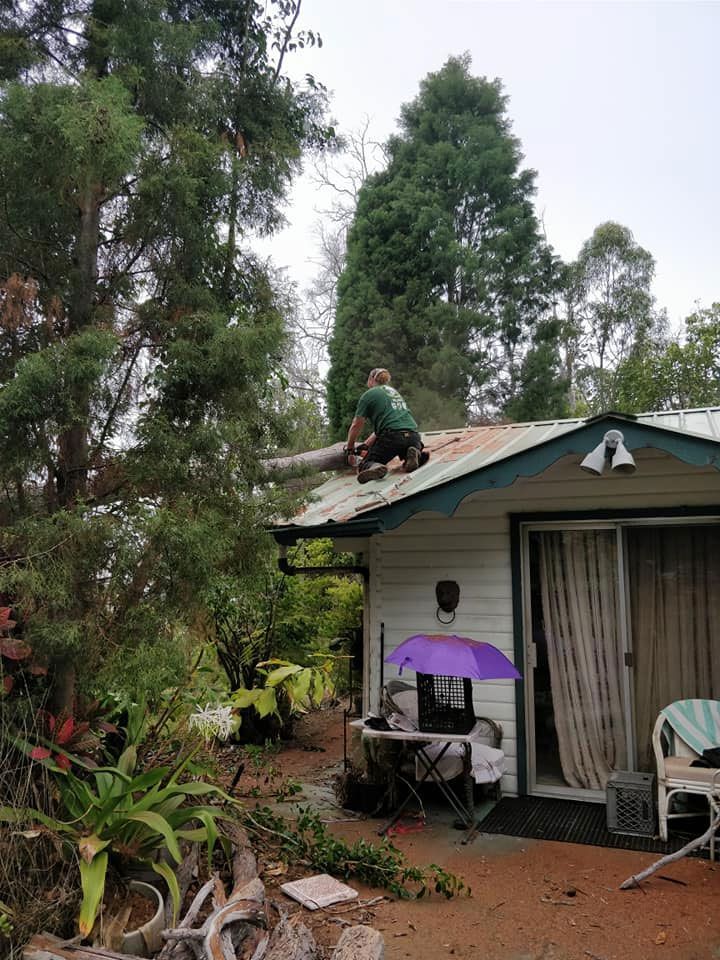 A man is sitting on the roof of a house.