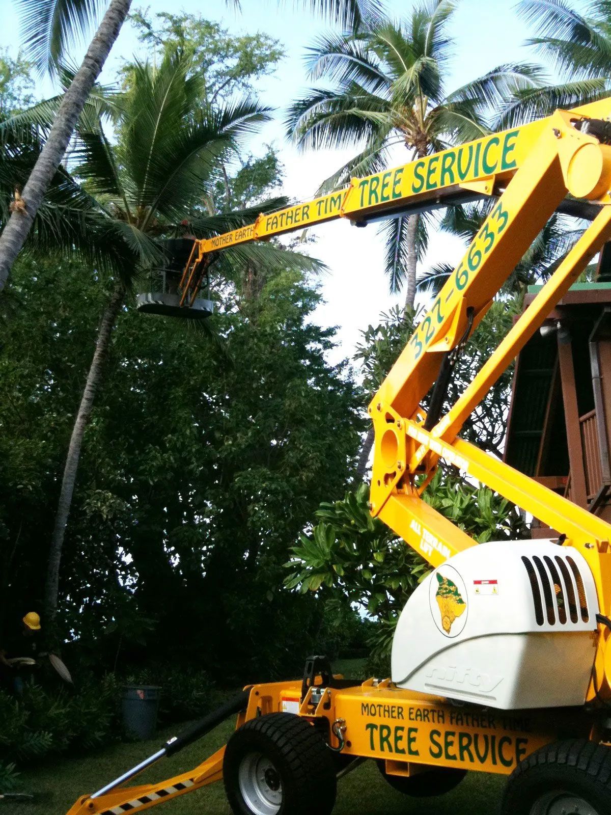 A yellow vehicle that says tree service on it