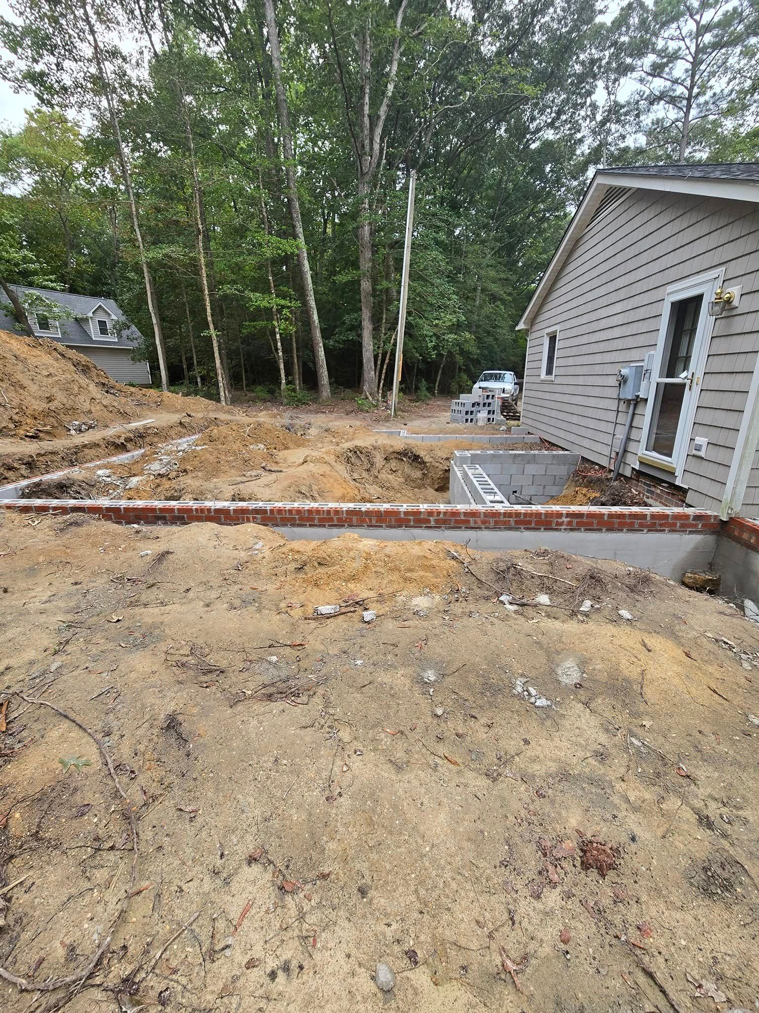 A house is being built in the middle of a dirt field.