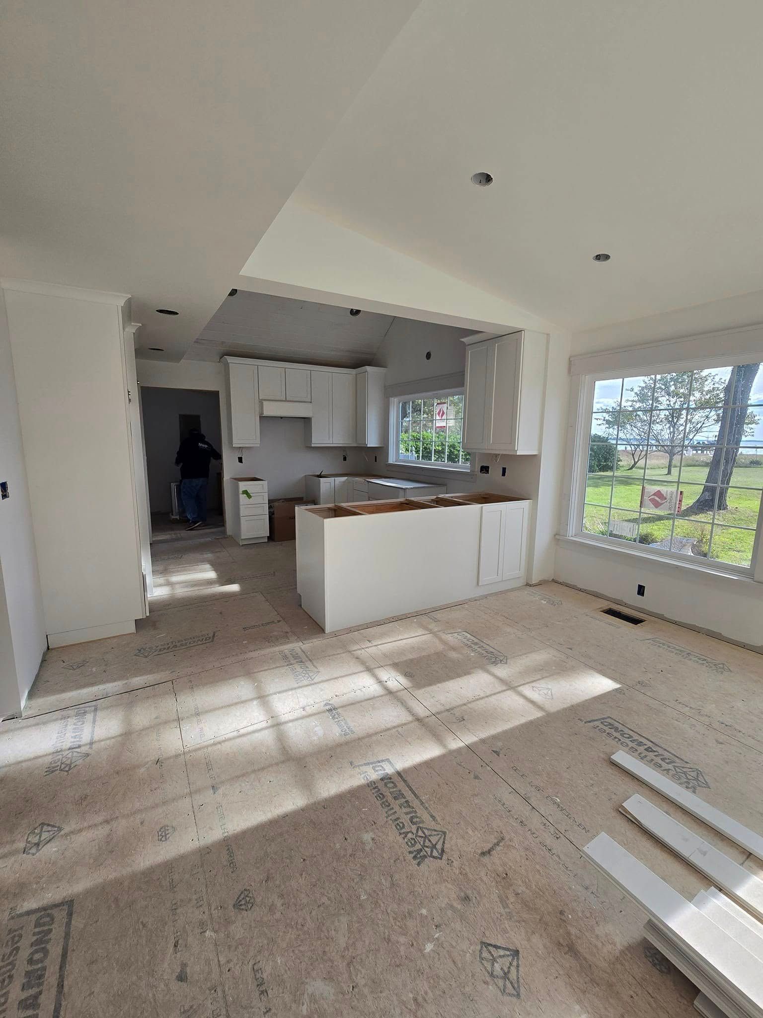 A kitchen is being built in a house with a lot of windows.