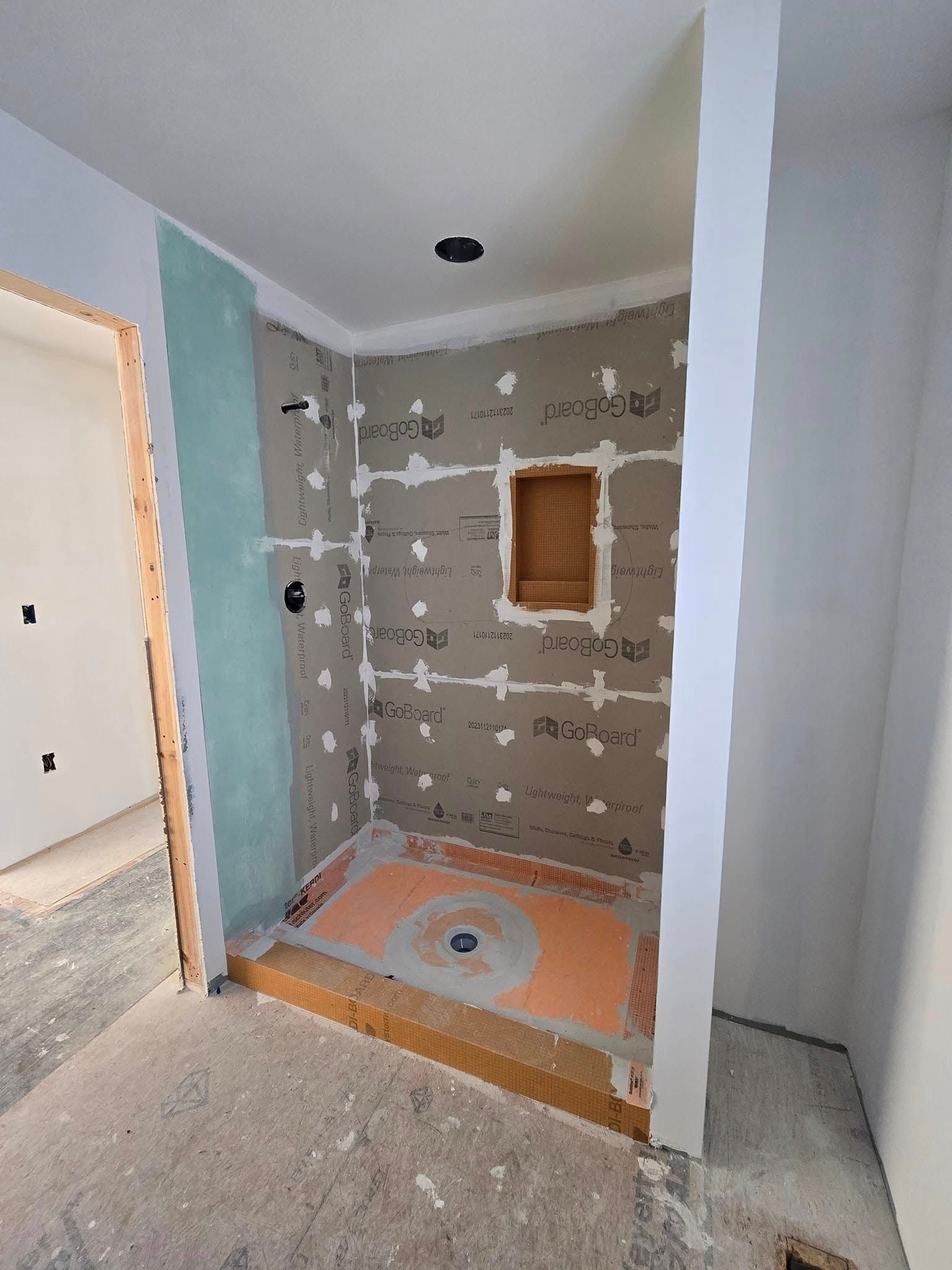 A bathroom under construction with a walk in shower.