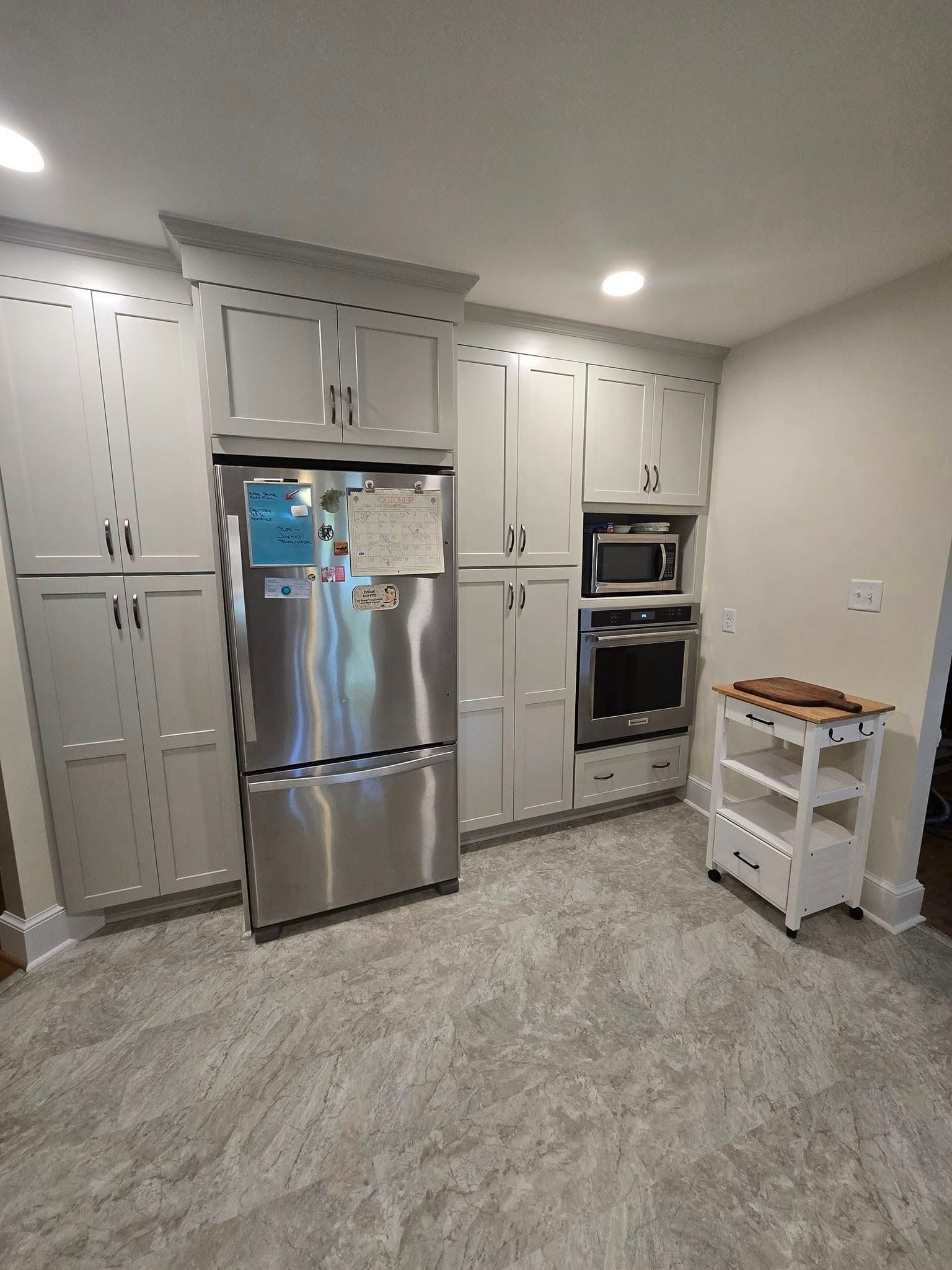 A kitchen with stainless steel appliances and white cabinets.